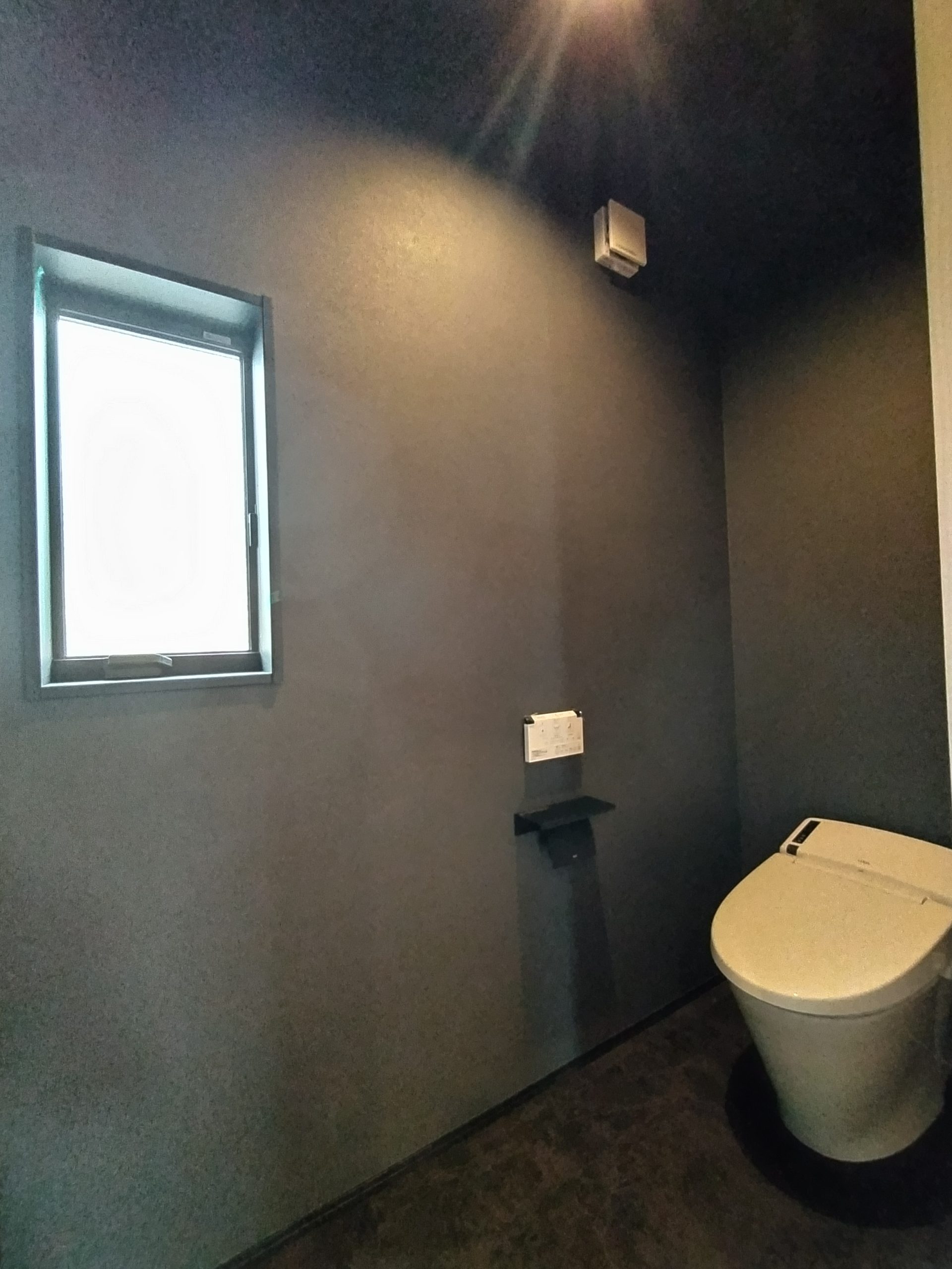 個性あふれるトイレの空間。ブラックのクロスを使うことでシンプルながらも空間を演出。