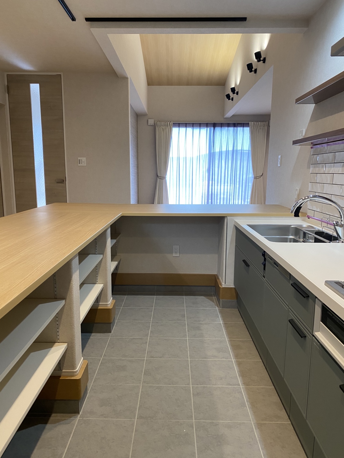 料理をしながら、宿題をする子どもと会話ができる囲むダイニングカウンター。 吹き抜けのある平屋だからこそ、家族の気配を感じながら、心地よい距離感で暮らせます。