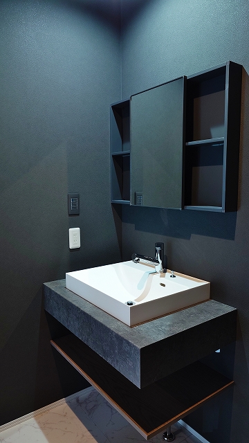 シンプルなデザインに、モルタル調カウンターの落ち着いた質感が映える洗面。